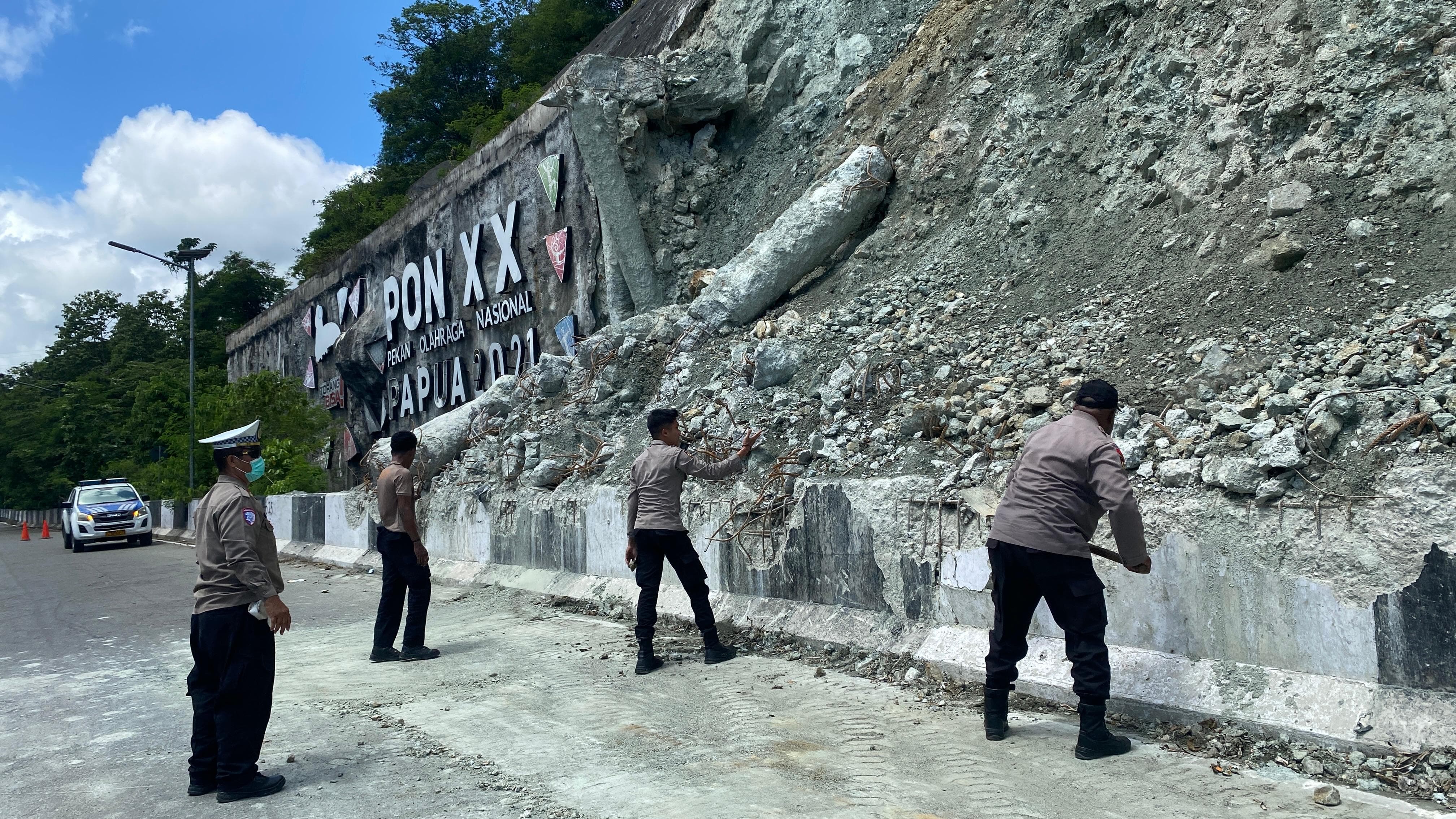 Anggota Polresta Jayapura Kota saat melakukan pembersihan material longsor di jalan Raya Ringroad, Rabu (11/2/2026).