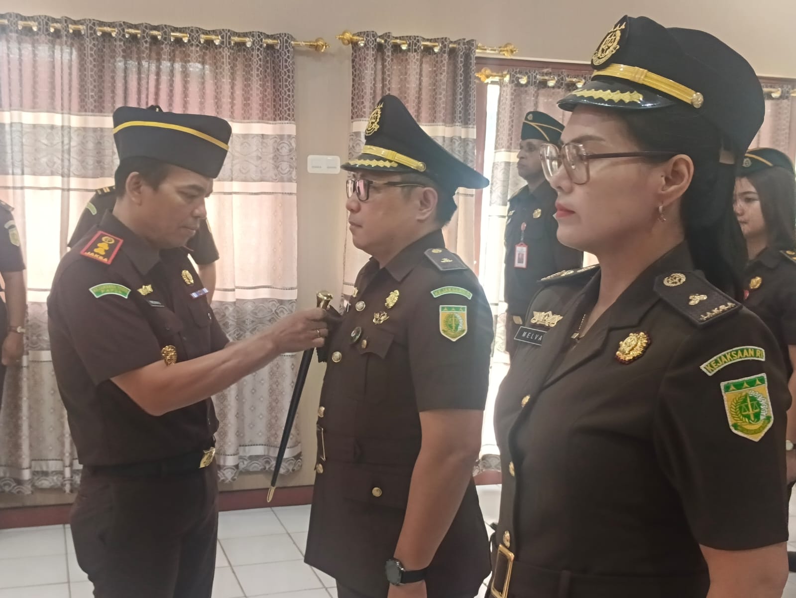 Kajari Merauke Paris Manalu saat memasang tanda jabatan ketika melantik Kasi Intel Pirly Maxon Momongan, dan Kasi Pidsus Yang Melva Rian, Kamis (19/2/2026).(Ceposonline.com/Sulo).