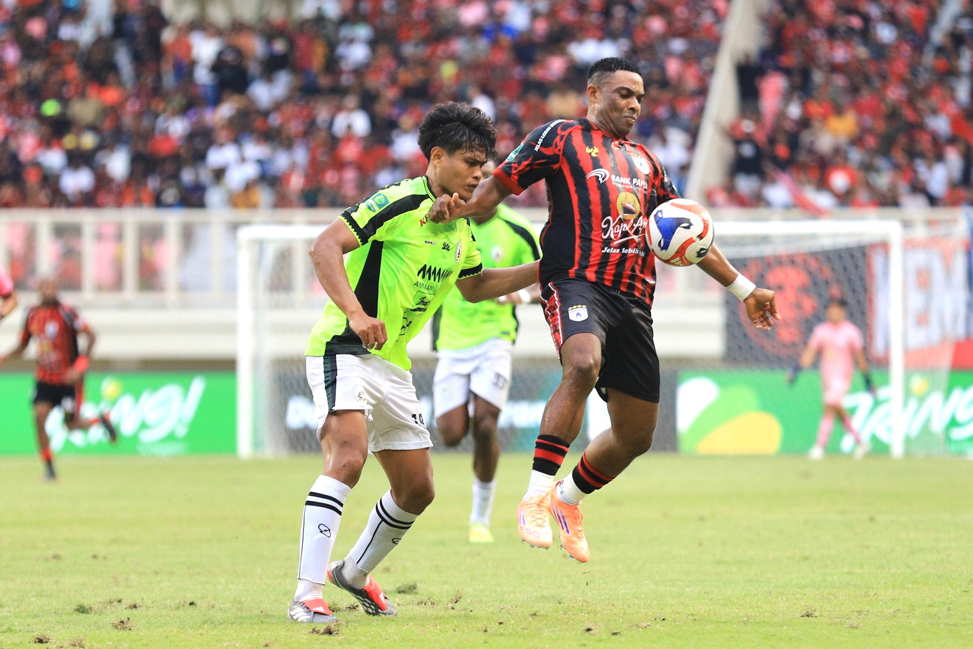Pemain Persipura, Osas Saha saat berebut bola dengan pemain PSS Sleman, Riko Simanjuntak saat bertanding di Stadion Lukas Enembe belum lama ini. (CEPOSONLINE.COM/ERIK).