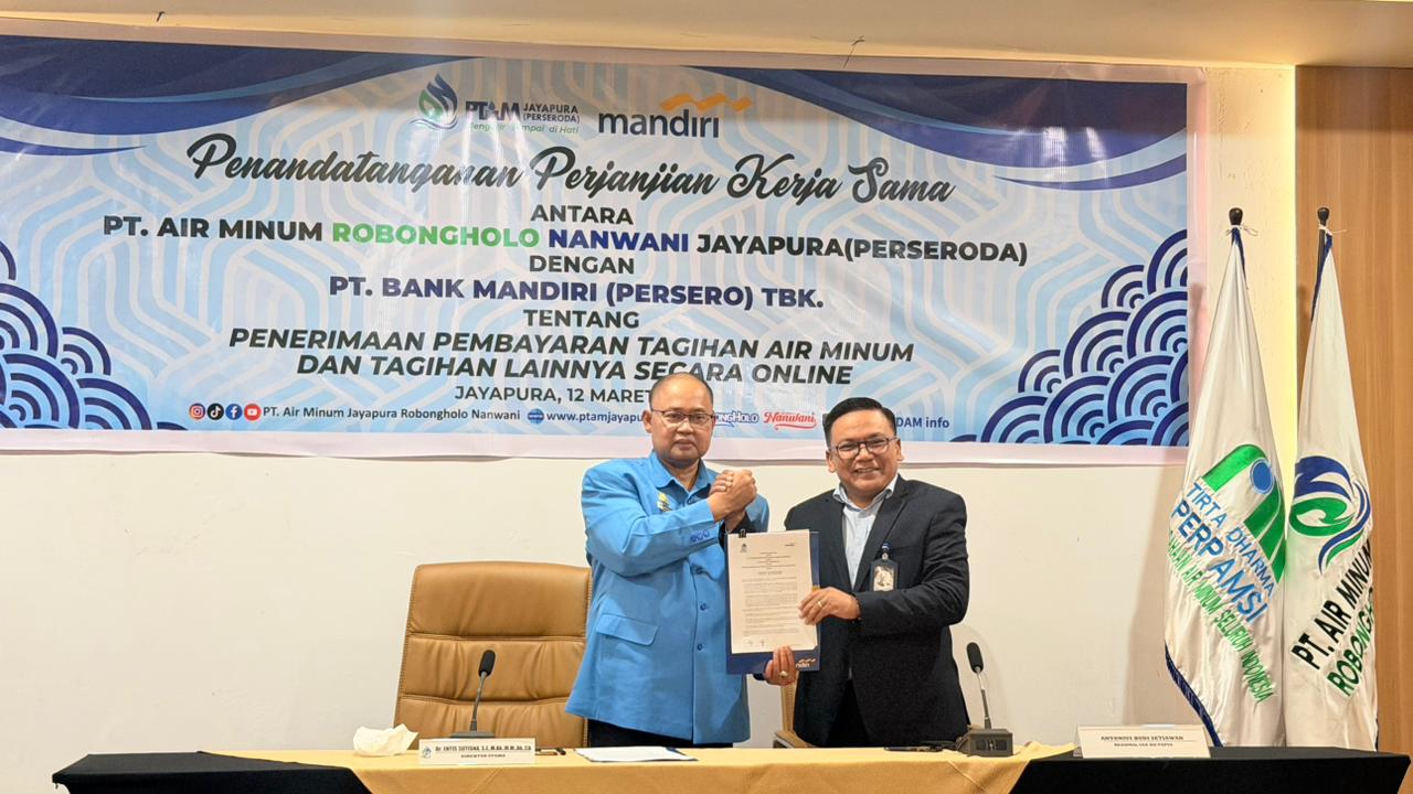 Dirut PT AMJ Robongholo Nanwani (Perseroda) Entis Sutisna bersama Regional CEO Bank Mandiri Region XII/Papua Antonius Budi Setiawan menunjukkan berita acara kerja sama di Ballroom Hotel Horison Ultima