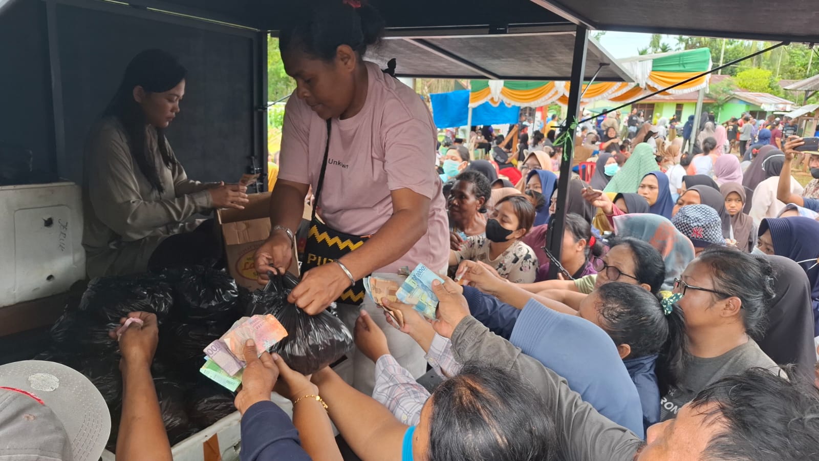 Masyarakat berdesak-desakan membeli sejumlah kebutuhan pokok dalam kegiatan pasar murah di Kampung Anjereuw, Sumberker, Distrik Samofa, Sabtu (15/03/2026).