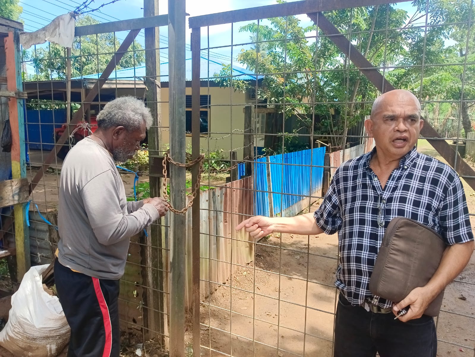 Pemilik lahan Simon Petrus Sabai Mahuze didampingi kuasa hukumnya Aloysius Dumatubun membuka sebagian gembok akses Perumahan Dinas Bandara Mopah Merauke.