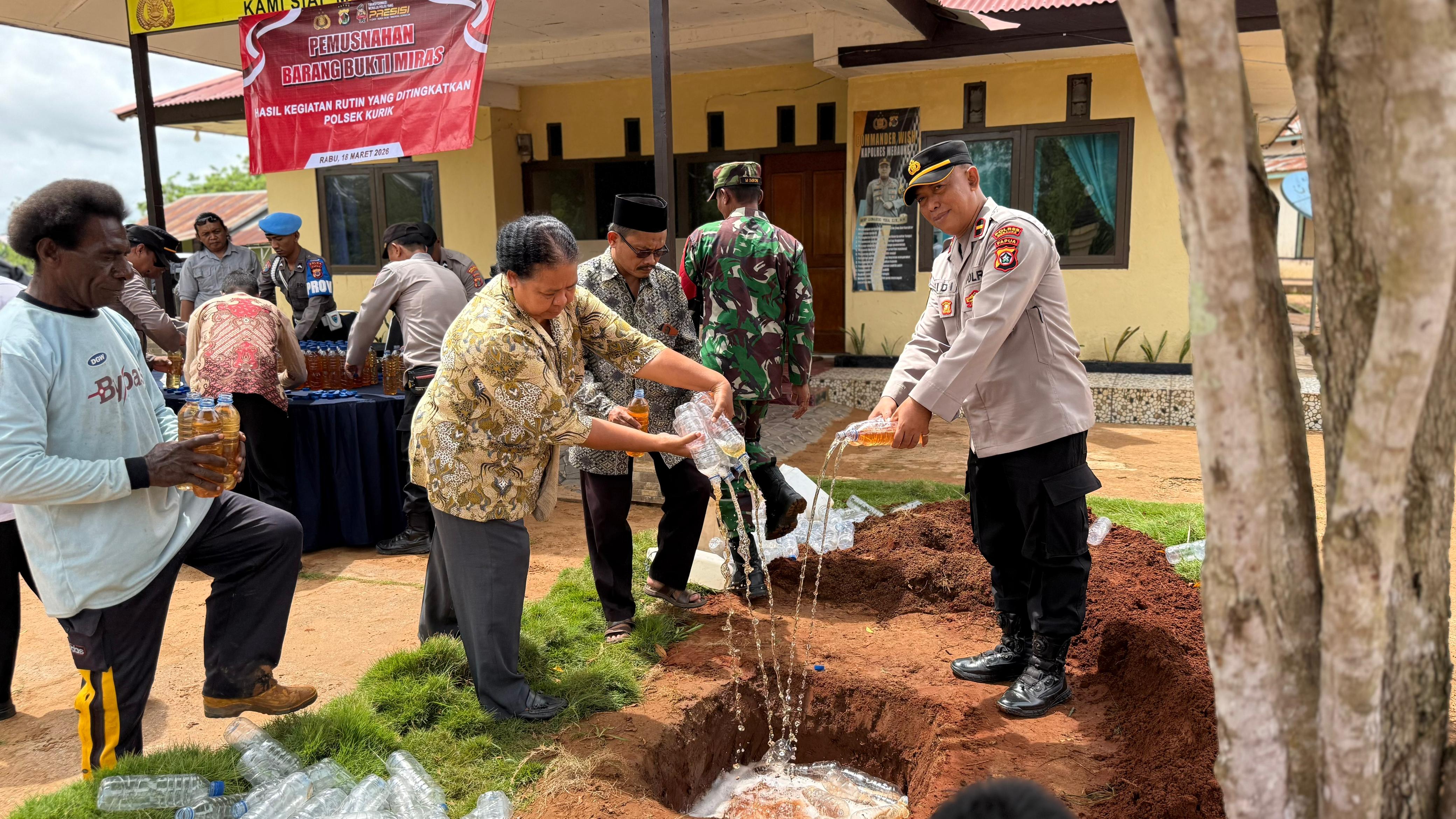 Plt Kapolsek Kurik Plt. Kapolsek Kurik Ipda Widi Mulyono bersama jajaran TNI dan seluruh stakeholder setempat saat melakukan pemusnahan Minuman Keras Lokal jenis Sopi dengan cara ditumpahkan (18/3/26)