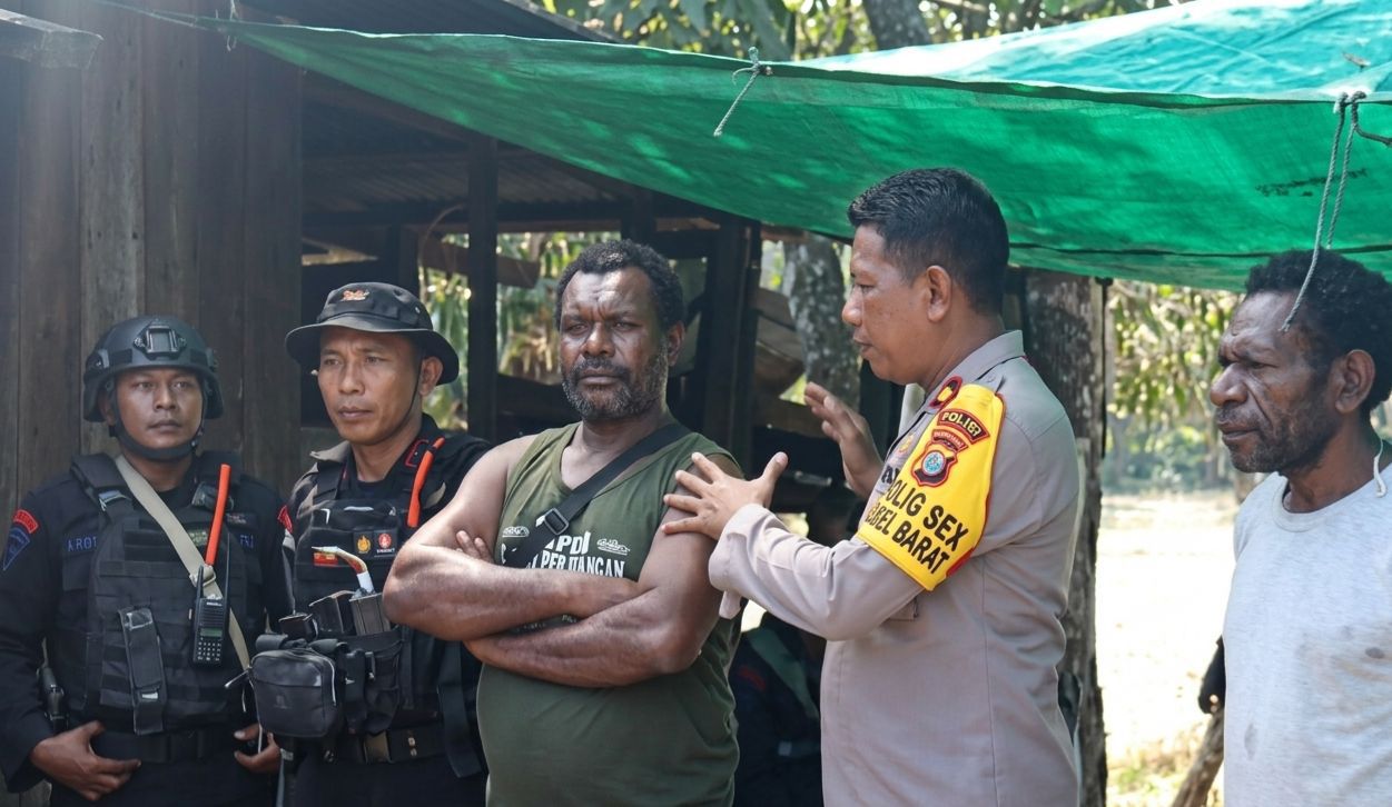 Kapolsek Mimika Barat sekaligus Perwira Pengendali (Padal) 1 Kapiraya, Mimika Barat Tengah, Ipda Muhamad Yani didampingi personel Brimob sedang berdialog bersama seorang warga. 