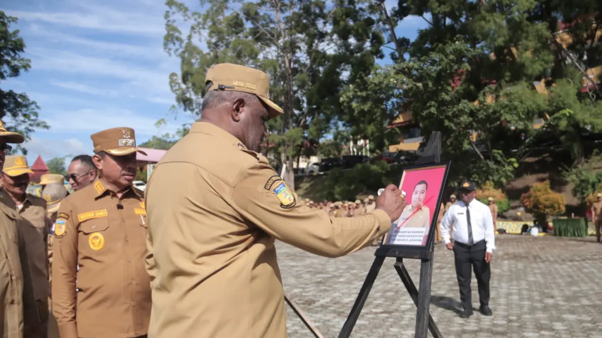 Wali Kota Jayapura, Abisai Rollo didampingi Wakil Wali Kota, Rustan Saru saat memberikan tanda silang merah pada foto ASN yang diberhentikan pada Apel Gabungan ASN, Senin (13/4/2026). (CEPOSONLINE.COM/HUMAS PEMKOT).