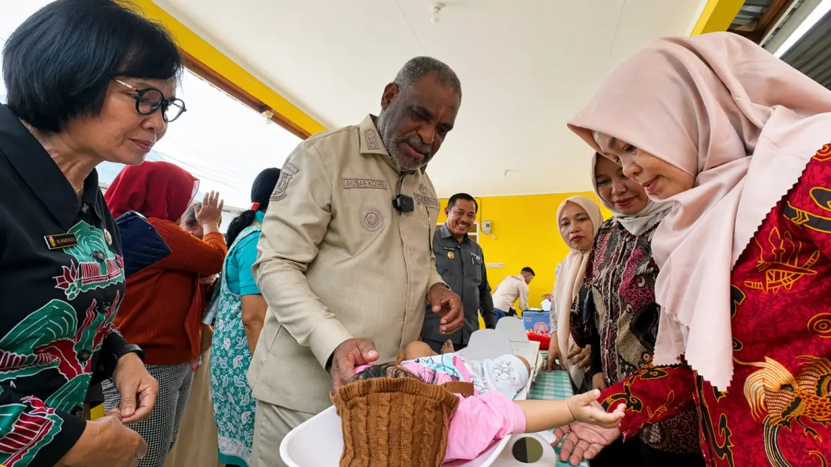 Wali Kota Jayapura, Abisai Rollo saat melihat salah satu balita ketika ditimbang berat badannya disela peresmian dua Posyandu di Abepura, Jumat (24/4/2026). (CEPOSONLINE.COM/HUMAS PEMKOT)