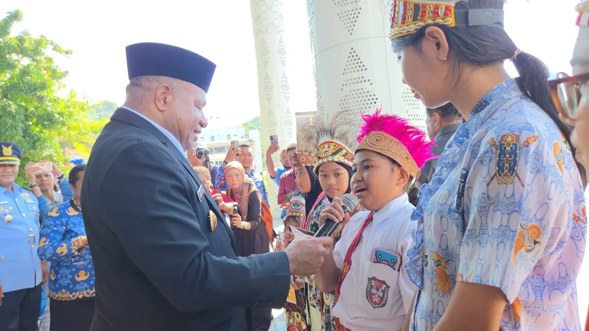 Gubernur Papua, Matius D Fakhiri saat memegangkan mikrofon ketika seorang siswi SD menyanyikan lagu “Embai Bosambewar” diperingatan Hari Pendidikan Nasional, di kantor gubernur, Sabtu (2/5/2026).(Ceposonline.com/Elfira)