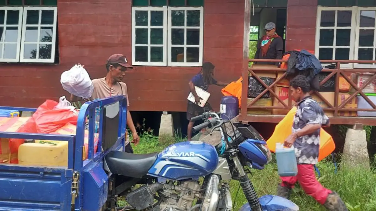 Anggota Polsek Mimika Barat sedang membantu pembongkaran logistik tenaga kesehatan di Pustu KM 4 Kapiraya, Mimika Barat Tengah. (Ceposonline.com/ Istimewa).&nbsp;