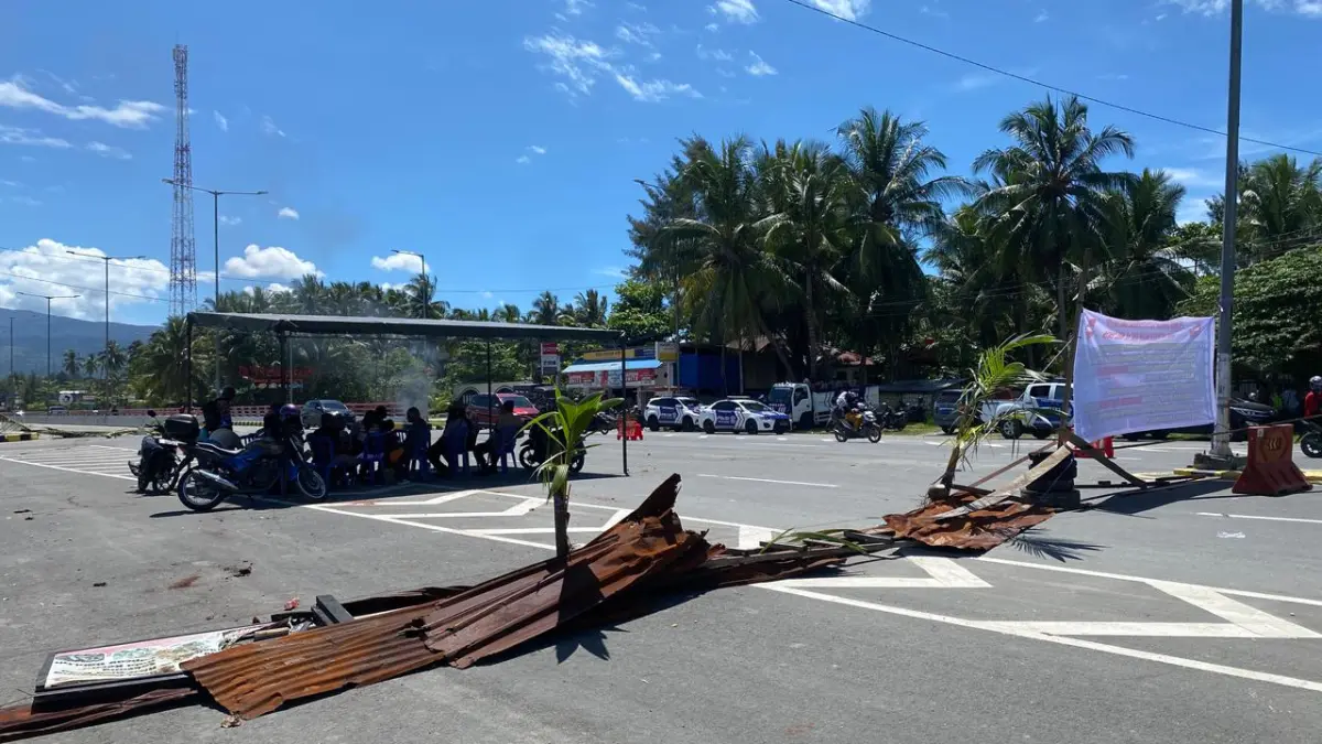 Masyarakat adat Tobati Enggros tampak menutupi sebagian jalur di jembatan merah dengan menggunakan ranting kelapa, Selasa (12/5/2026)