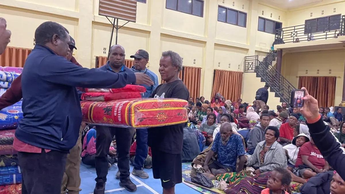 Kepala Kesbangpol Provinsi Papua Pegunungan Agustinus Howay saat menyerahkan bantuan Gubernur Papua Pegunungan &nbsp;kepada Koordinator Pengungsian Theo Hesegem di Aula Polres Jayawijaya, Jumat (15/5/2026) Malam. (CEPOSONLINE.COM/DENI) 