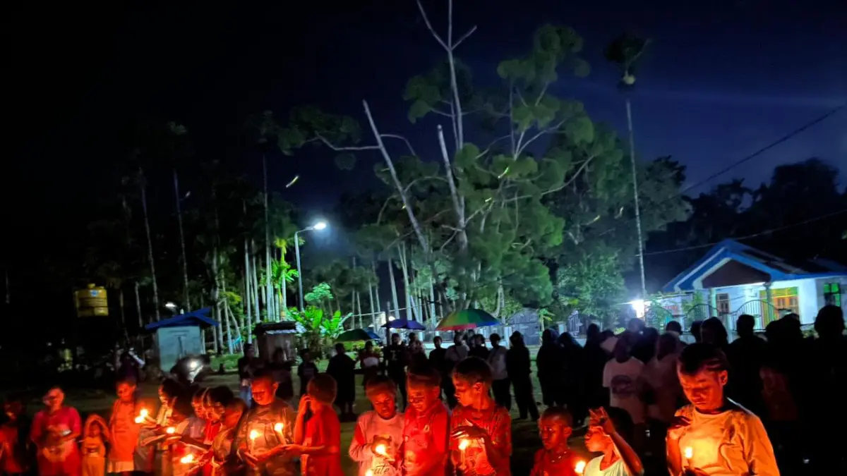 Anak-anak Sekolah Minggu Jemaat Kingmi Bukit Zaitun Kali Susu Nabire menyalakan lilin dan berdoa untuk teman sebaya mereka, Aliko Walia yang meninggal dunia karena tertembak pada konflik bersenjata di Distik Kembru, Kabupaten Puncak, Rabu (20/5/2026).(CEPOSONLINE.COM/THERESIA F. TEKEGE).