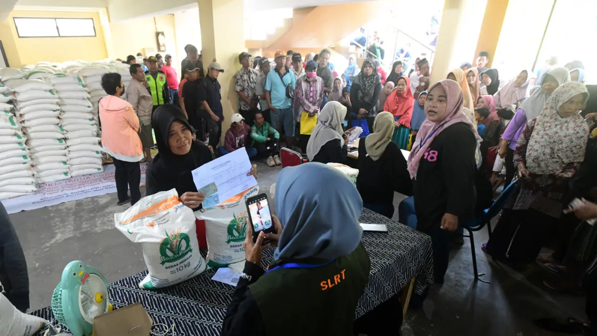 Keluarga Penerima Bantuan Pangan (PBP) antri untuk menerima Bantuan Pangan Non Tunai (BPNT) beras 20 kg di Kantor Kelurahan Rangkapan Jaya Baru, Depok, Jawa Barat, Kamis, (24/07/2025). (Dery Ridwansah/ JawaPos.com)