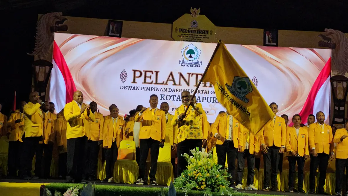 Ketua DPD Golkar Provinsi Papua, Mathius Fakiri saat menyerahkan petaka Golkar kepada Abisai Rollo sebagai Ketua terpilih DPD Golkar Kota Jayapura. (CEPOSONLINE.COM/HANS PALEN).