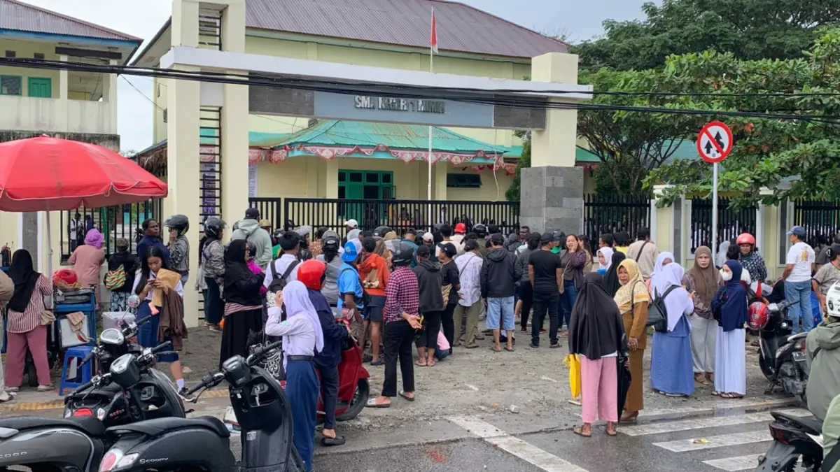 Ratusan orang tua dan siswa yang berdiri mengantri menunggu giliran di depan pagar SMA Negeri 1 Mimika, Senin (22/6/2026). ( CEPOSONLINE.COM/MOH. WAHYU WELERUBUN).