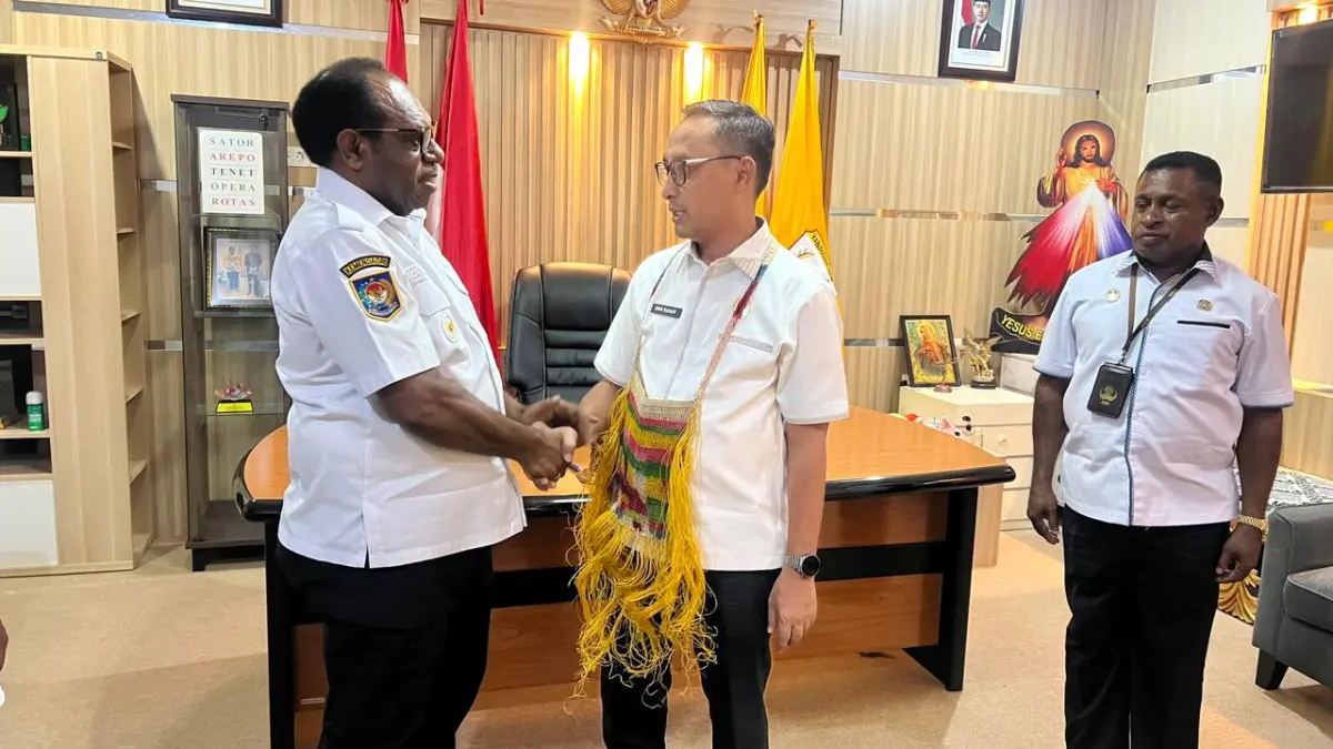 Bupati Keerom, Piter Gusbager saat mengalungkan noken kepada Kepala Kanreg IX BKN Jayapura, Nur Hasan di Kantor Bupati Keerom, Rabu (24/6/2026).CEPOSONLINE.COM/ERIANTO).