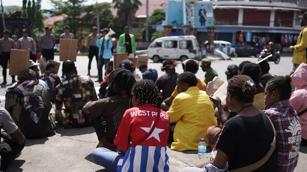 Suasana di tengah barisan massa, tampak salah satu orang peserta aksi mengenakan kaos merah bertuliskan "West Papua" lengkap dengan simbol bintang kejora, Rabu (8/7/2026).&nbsp;