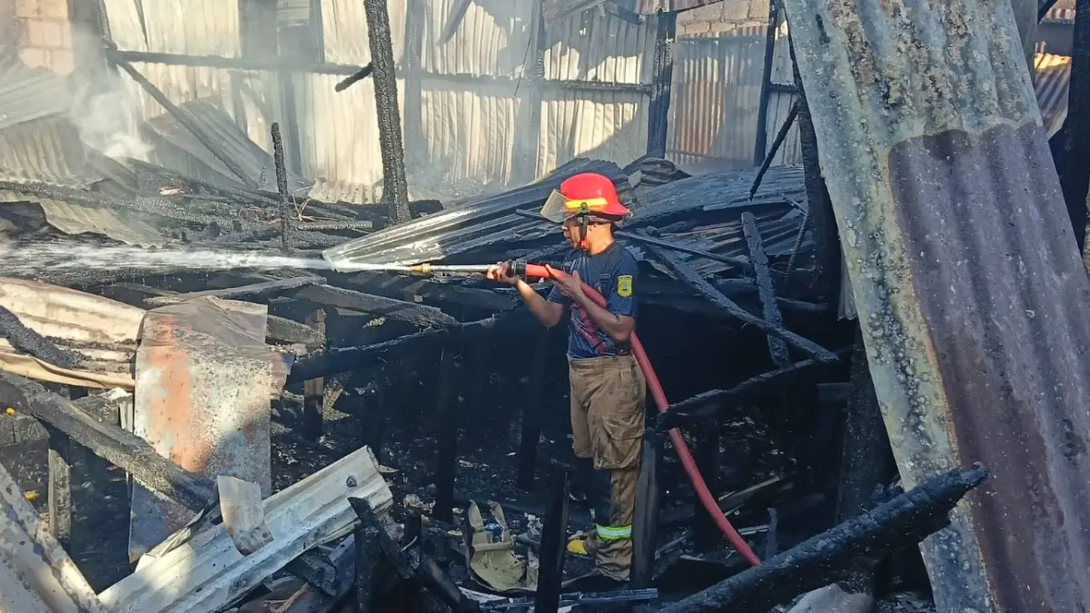 Petugas pemadam kebakaran berupaya memadamkan api yang menghanguskan rumah warga di Jalan Tobati-Enggros, belakang Hotel Hamadi Beach, RT 06/RW 10, Distrik Jayapura Selatan, Minggu (12/7/2026) siang.(CEPOSONLINE.COM/PRIYADI)