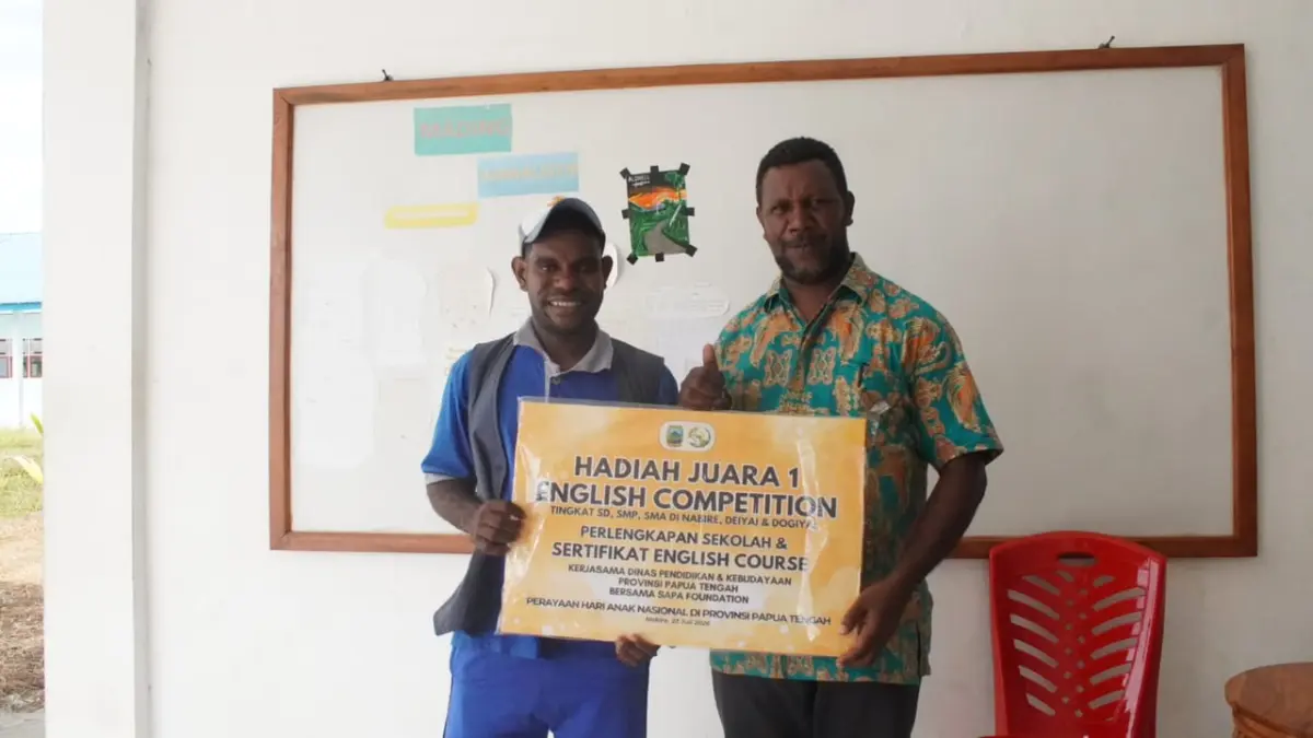 Kepala SMA Negeri Meepago, Otopianus Tebai foto bersama dengan Melian Obaipa, Siswa SMA Negeri Meepago yang meraih Juara I English Competition tingkat SMA pada peringatan Hari Anak Nasional 2026 di Papua Tengah. (CEPOSONLINE.COM/THERESIA F. TEKEGE)