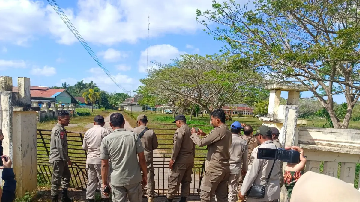 Satpol PP Kabupaten Merauke dibackup Personel Polres Merauke saat membuka palang pintu masuk Kantor Dinas Kesehatan Kabupaten Merauke, Jumat (31/7/2026)&nbsp;&nbsp;

(CEPOSONLINE.COM/SULO)