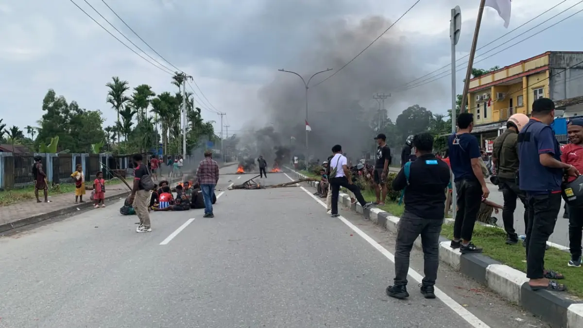 Warga melakukan aksi blokade dengan menggunakan kayu dan bakar ban di Jalan Cenderawasih, depan Lorong Garuda dan Lorong Celebes, Mimika, Papua Tengah, Kamis (6/8/2026). (CEPOSONLINE.COM/MOH. WAHYU WELERUBUN).&nbsp;
