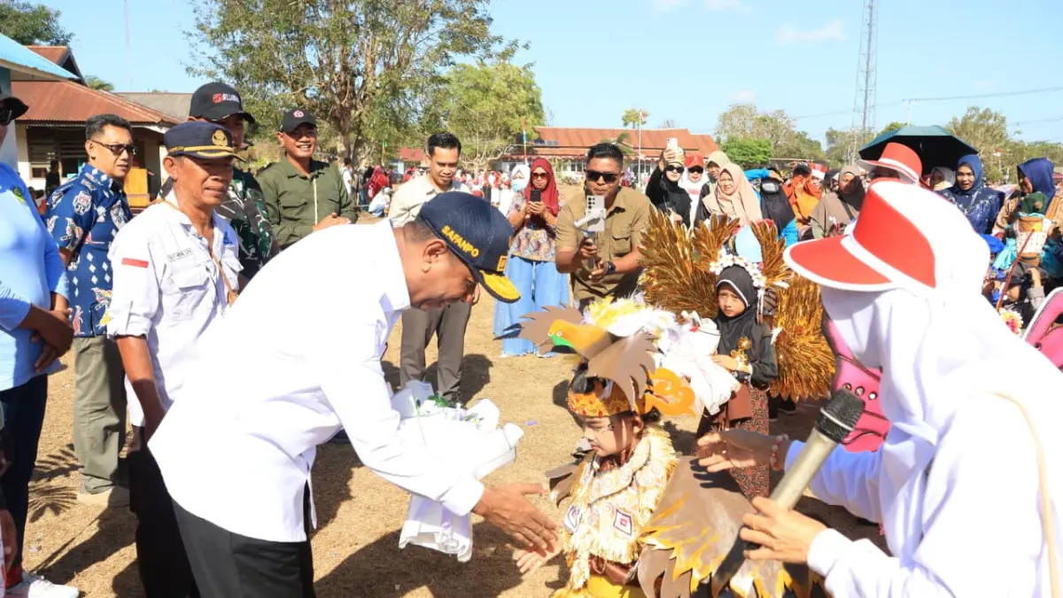 Gubernur Papua Selatan Apolo Safanpo saat menerima buket bunga dari seorang gadis cilik, peserta karnaval budaya dan pembangunan di Distrik Kurik, Sabtu (15/8/2026). (CEPOSONLINE.COM/BIRO UMUM PAPSEL)&nbsp;