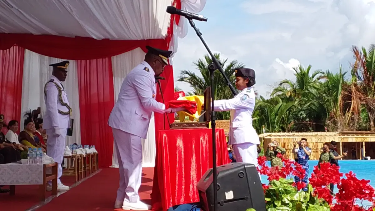Bupati Jayapura, Yunus Wonda menyerahkan bendera merah putih kepada pembawa baki Ananda, Meychel Verolin Mehue, siswa SMA YPPK Sentani, dalam pelaksanaan HUT RI ke- 81 di Kabupaten Jayapura, Senin(17/8/2026).
(CEPOSONLINE.COM/ROHANA WENGGI)