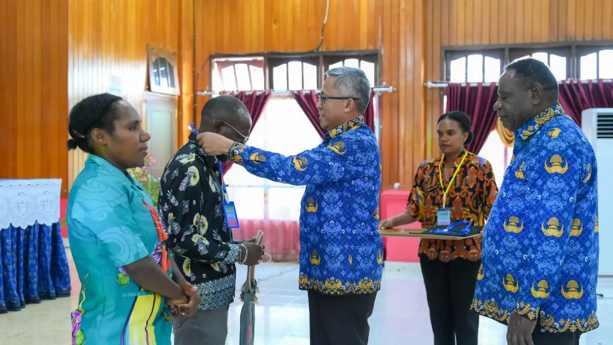 Asisten II Bidang Perekonomian dan Pembangunan Setda Provinsi Papua Tengah, Tumiran saat menamatkan tanda peserta dan foto bersama dengan peserta di Aula Guestt House Nabire, Kamis, (20/8/2026). (CEPOSONLINE.COM/HUMAS PEMPROV)