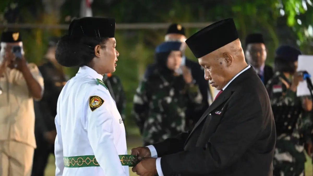 Bupati Biak Numfor Markus Mansnembra tengah mamasang atribut Paskibraka di Lapangan Terbuka, Minggu (16/8/2026). (CEPOSONLINE.COM, FIKTOR PALEMBANGAN)&nbsp;