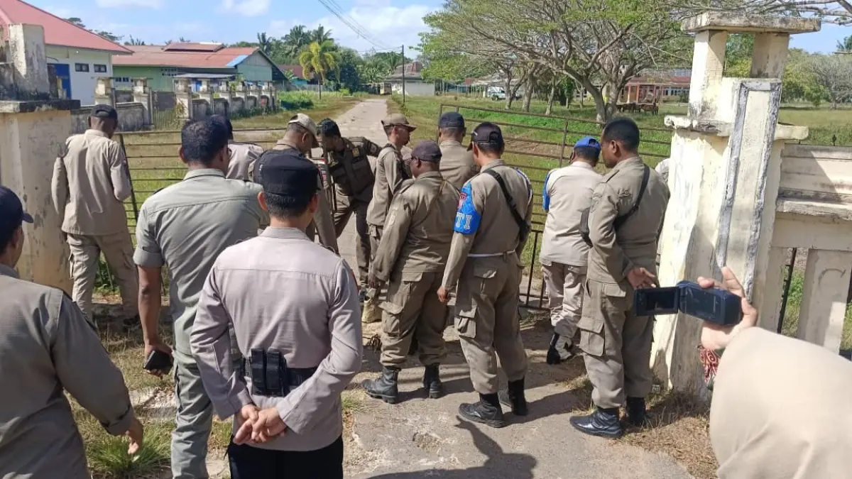 Satpol PP Kabupaten Merauke membuka palang Kantor Dinas Kesehatan Kabupaten Merauke beberapa waktu lalu. Mulai Kamis (27/8/2026), Satpol PP kembali menempatkan personel untuk mengamankan aktivitas pegawai di lingkungan Dinas Kesehatan Kabupaten Merauke.(CEPOSONLINE.COM/SULO)&nbsp;