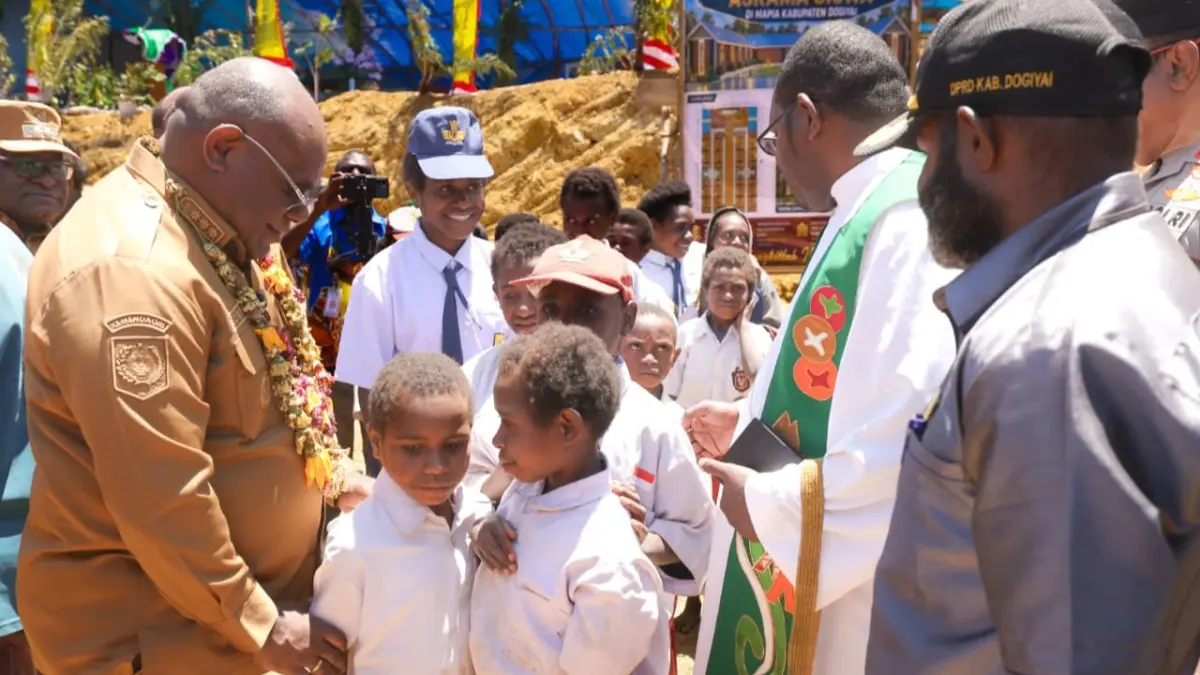 Seorang siswa SD saat mengkalungkan bunga kepada Gubernur Papua Tengah, Meki Nawipa bersama Bupati &nbsp;Dogiyai, Yudas Tebai saat mengunjungi kampung Omakapau, Diyoudimi, Distrik Mapia, Kabupaten Dogiyai, Senin, (7/9/2026). (CEPOSONLINE.COM/HUMAS PEMPROV)