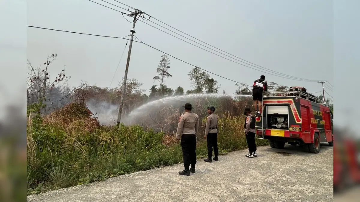 Anggota Polisi saat memadamkan titik Api yang menyebar di Nabire, Senin (14/9/2026). (CEPOSONLINE.COM/HUMAS POLDA PAPUA TENGAH)