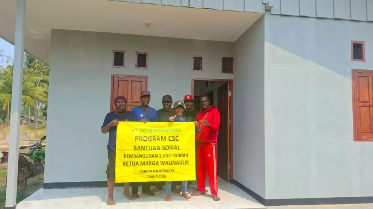 Yustinus Walinaulik, salah satu ketua marga di Kampung Iwol berpose di depan rumah pemberian dari PT. Dongin Prabhawa (DP).