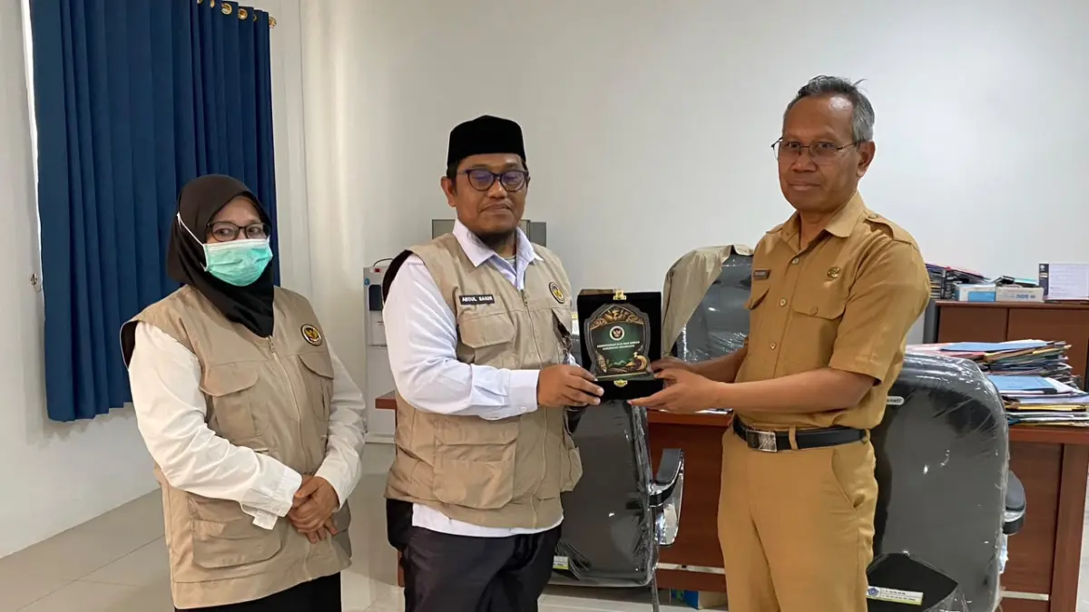 Kepala Kantor Kemenhaj Kabupaten Jayawijaya, Abdul Sakir (kiri), menyerahkan plakat kepada Plt. Sekda Kabupaten Jayawijaya, Tinggal Wusono, saat melakukan audiensi mengenai integrasi data jemaah haji di Jayawijaya, Senin (12/10/2026). (Foto: Dok. Kemenhaj Jayawijaya).