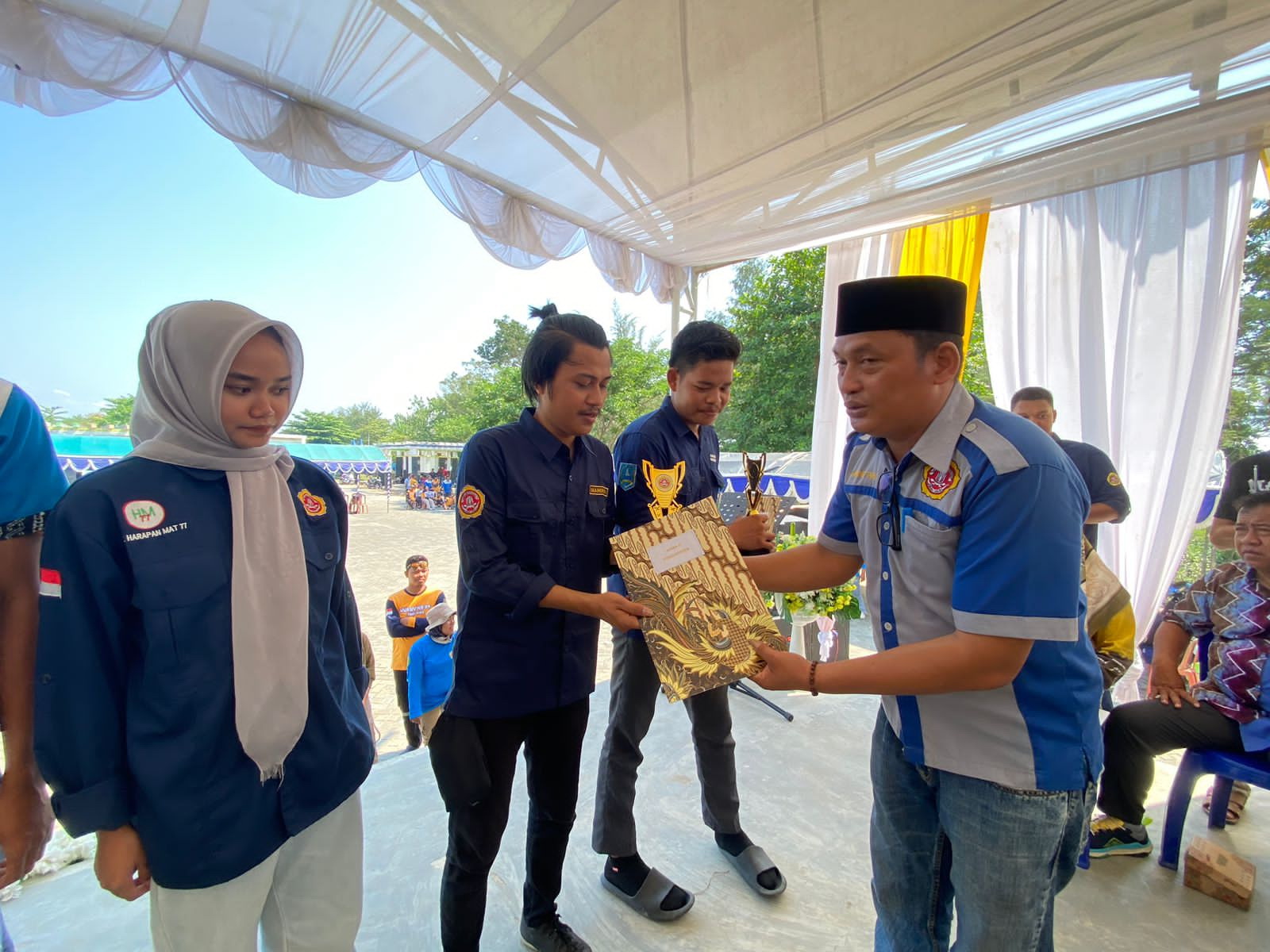 TERIMA PIALA: Salah satu anggota Karang Taruna Mahindra Desa Timbun Tulang Batumandi, Hindri, menerima piala pada gelaran Kemah Karya Bakti Wisata Karang Taruna (KKBWKT) XXXIV se Kalimantan Selatan.