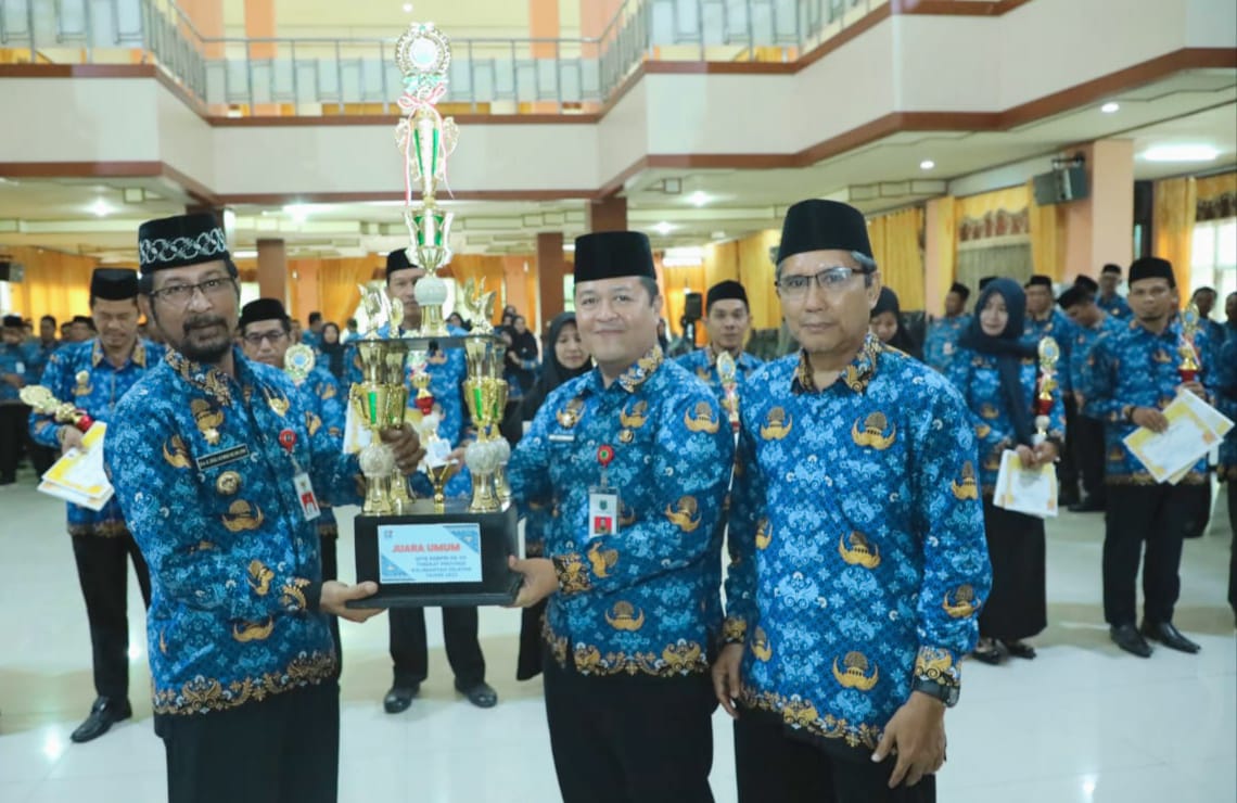 Pj Bupati HSU Zakly Aswan didampingi Ketua Korpri HSU Adi Lesmana, menyerahkan tropi MTQ Korpri tingkat Kalsel di Aula Dr KH Idham Chalid.