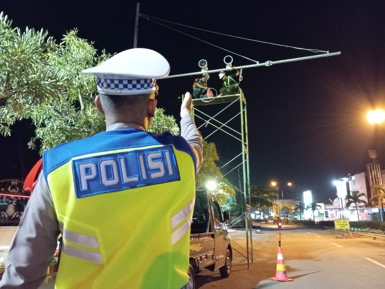 PEMANTAU ELEKTRONIK: Petugas saat memasang kamera ETLE di dekat Bundaran Sirang Pitu atau depan rumah dinas Bupati Tapin.(foto: Rasidi Fadli/Radar Banjarmasin)