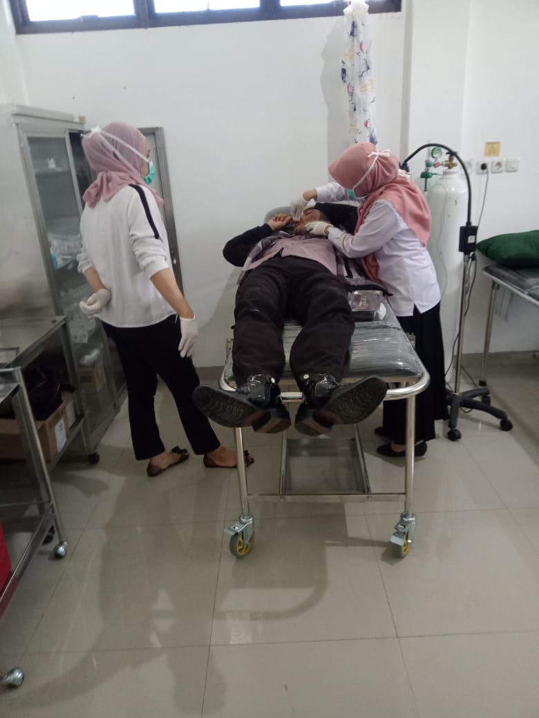 PENANGANAN: Jakaria, sekuriti MAN IC Tala sedang mendapat perawatan di Puskesmas Panggung karena ditabrak lari Avanza Silver, Rabu (27/12) siang. (Foto : Grup Suara Rakyat)