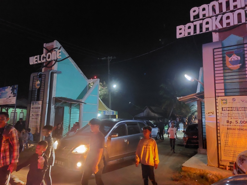 MEMBELUDAK: Para wisatawan keluar masuk lokasi Pantai Batakan Baru di Desa Batakan, Kecamatan Panyipatan, Senin (1/1) dini hari.