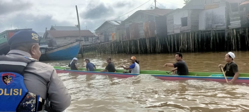 PATROLI: Anggota Polairud dari Markas Unit Gunung Meranti memantau lomba dayung tradisional di Sungai Martapura, Banjarmasin Selatan, Ahad (7/1).