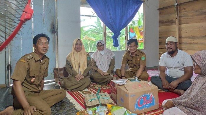 SERAHKAN BANTUAN: Dinas Perikanan Tanbu menyerahkan bantuan sembako kepada istri nelayan meninggal di DAS Batulicin.