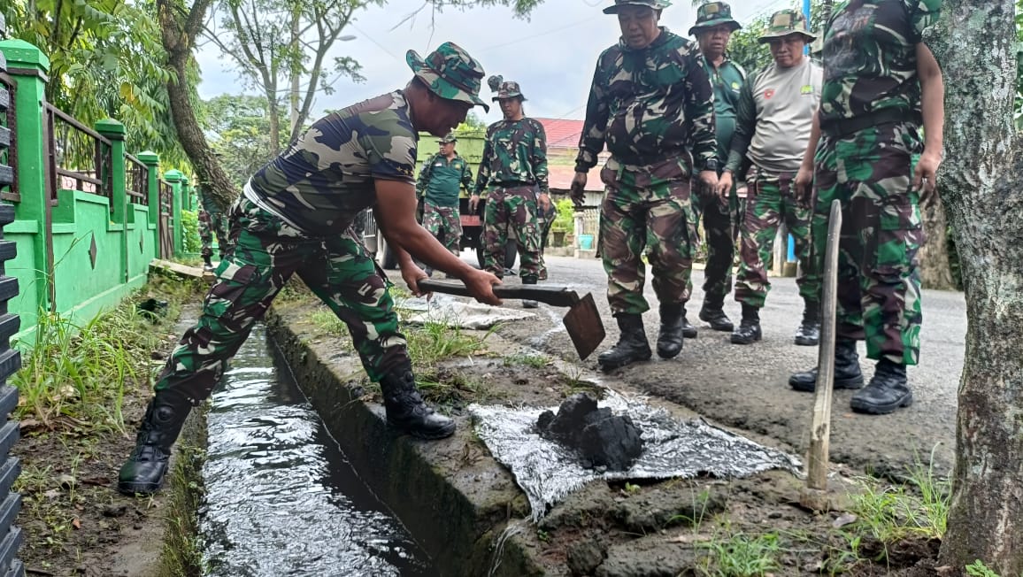 ANGKAT LUMPUR: Anggota Kodim 1010 Tapin bergotong royong membersihkan drainase di jalan MTQ.(Foto: Kodim 1010/Tapin/Radar Banjarmasin)