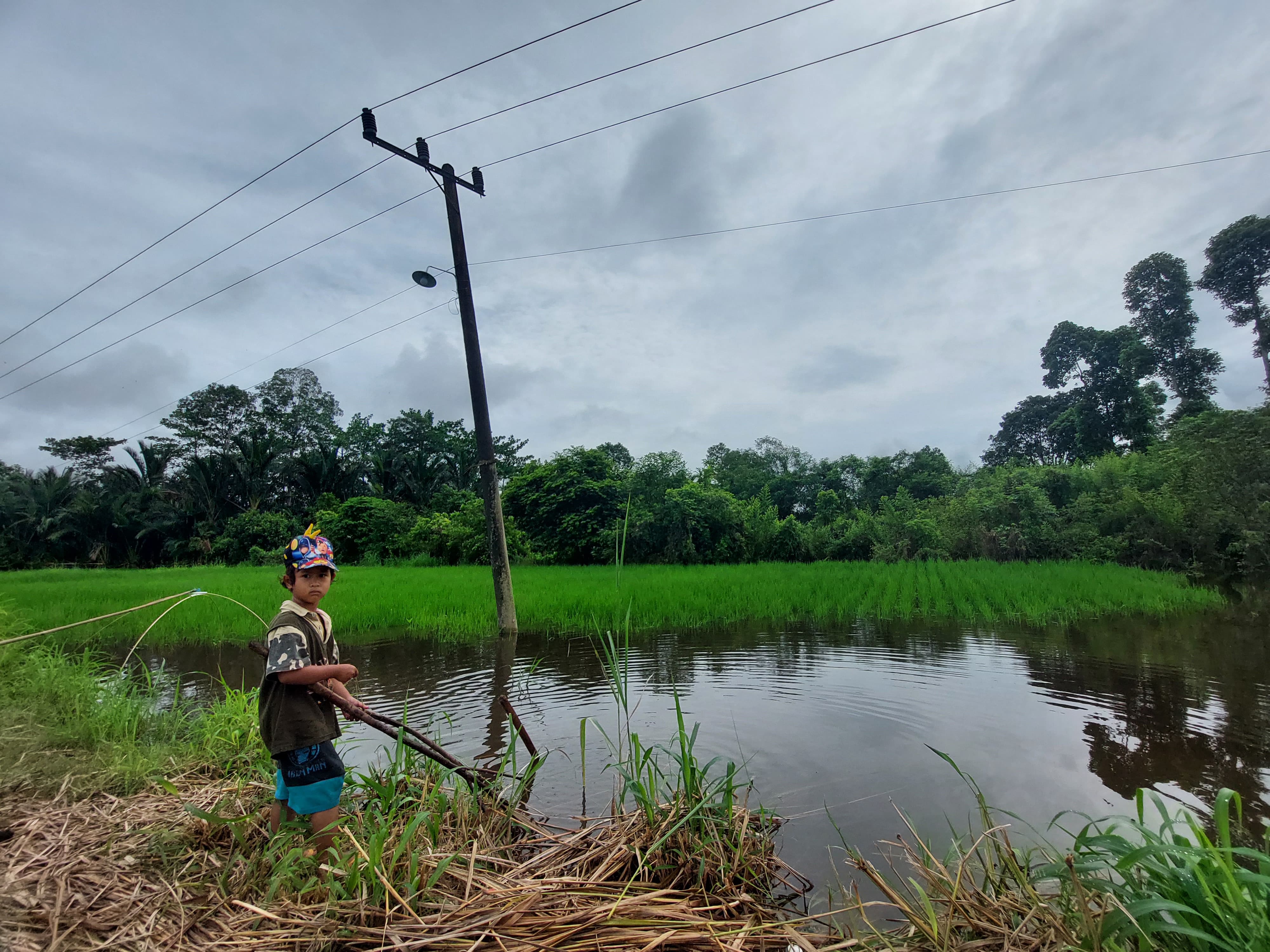 TERENDAM: Seorang anak petani bermain di sawah milik warga di Hulu Sungai Tengah (HST) yang terendam.(foto: Jamaluddin/Radar Banjarmasin)