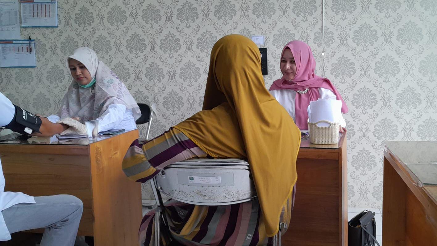 PENANGANAN MEDIS: dr Yeni Kusuma Dewi (kanan) memeriksa kesehatan warga terdampak banjir di HSU. (Foto: M Akbar/Radar Banjarmasin)