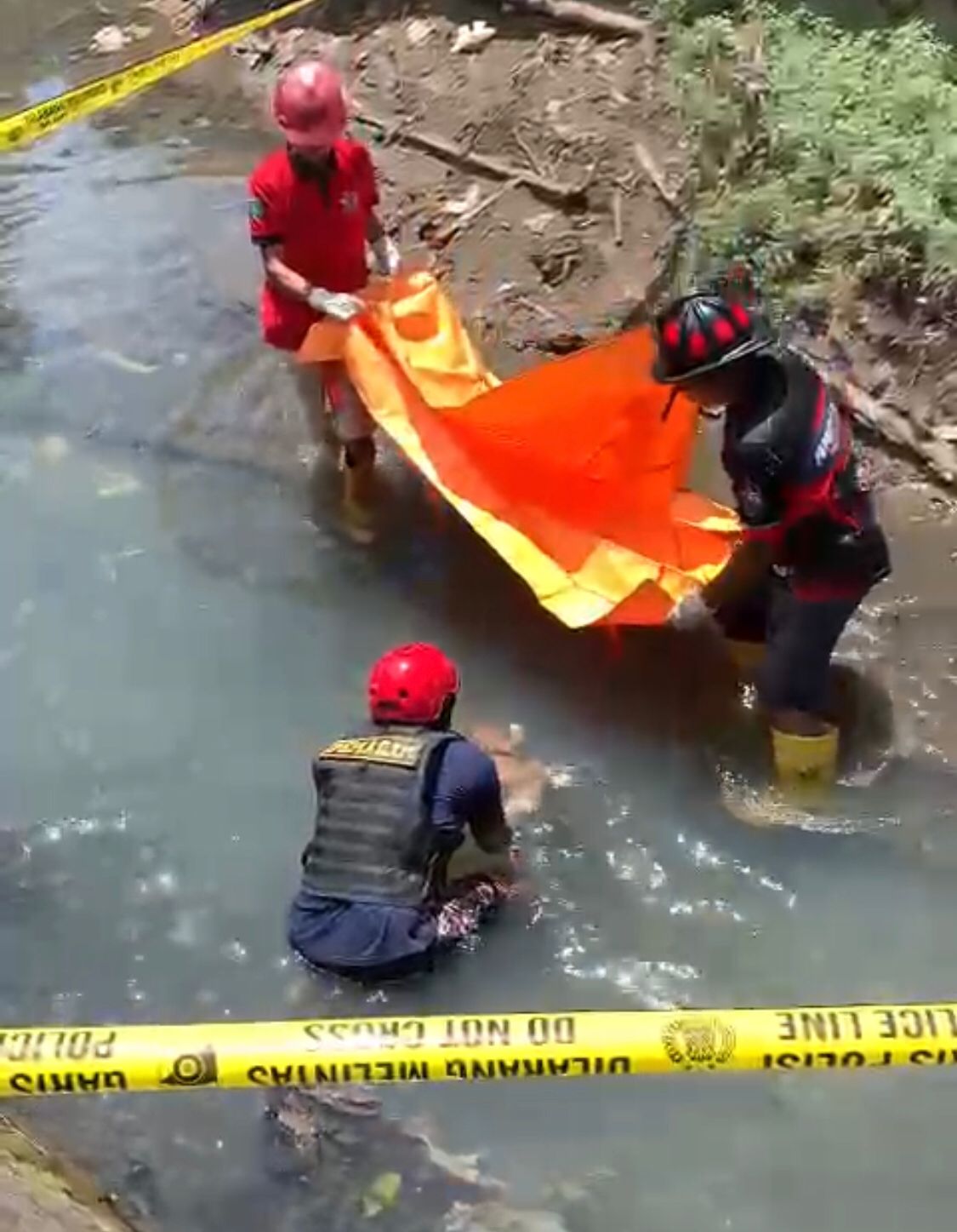 LARUT: Tim Damkar dan relawan mengevakuasi mayat bayi dari dalam sungai.(Foto: Relawan untuk Radar Banjarmasin)