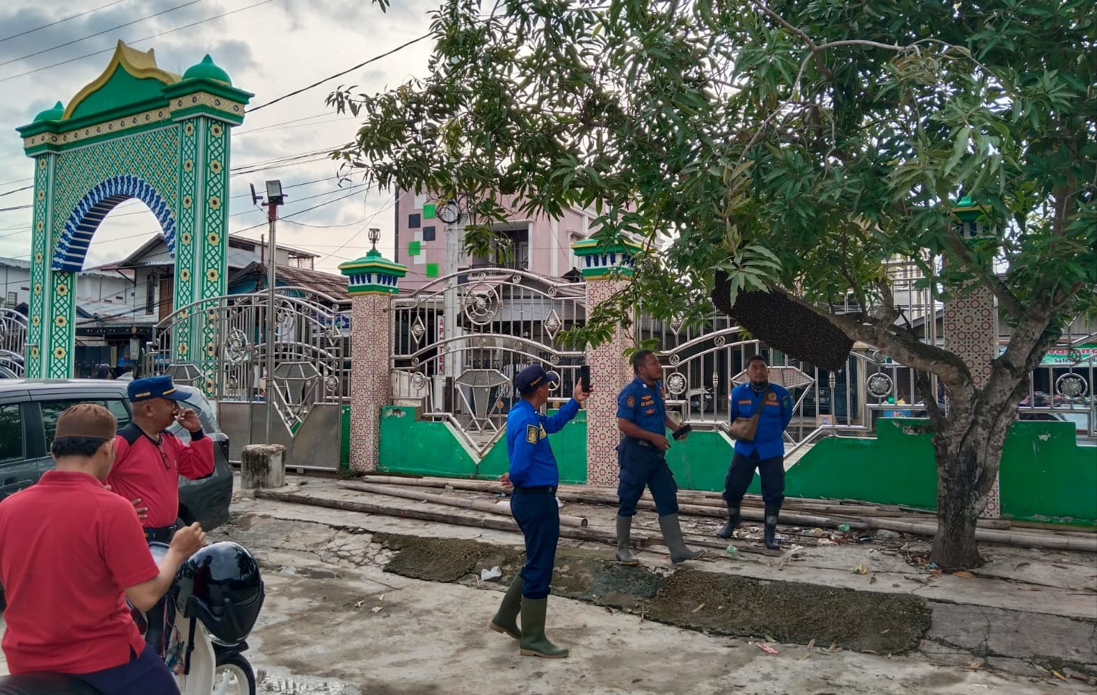 AWAS DISENGAT: Anggota Pol PP dan Damkar HSU mengevakuasi kawanan lebah di sekitar Masjid Pancasila, Kabupaten HSU, Kamis (18/1/2024).(Foto: Damkar HSU/Radar Banjarmasin)