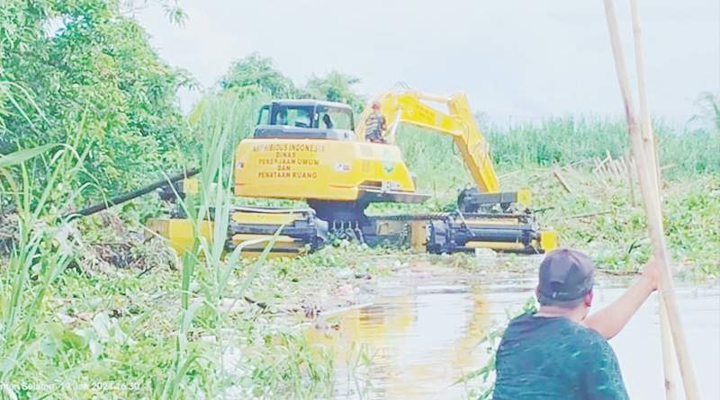 TERSUMBAT: Excavator Amphibious milik Dinas PUPR HSU berupaya membuka sumbatan sampah di Sungai Louk Maut Desa Kayakah.