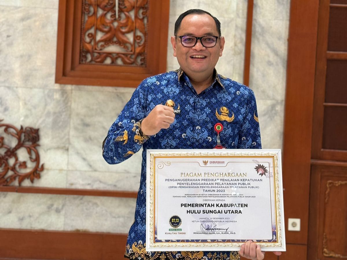 PRESTASI: Kepala Disdukcapil HSU Tony Fitriady SSTP, saat foto dengan piagam penghargaan dari Ombudsman RI Perwakilan Kalsel.(Foto: M Akbar/Radar Banjarmasin)