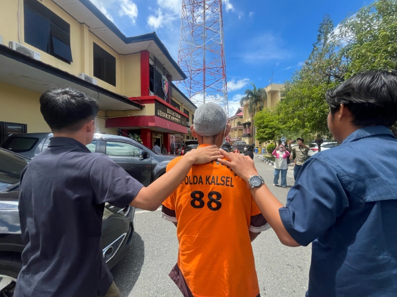 TERSANGKA: SR, 41 tahun, digiring penyidik ke Unit PPA Ditreskrimum Polda Kalsel, Kamis (1/2). SR menjadi tersangka persetubuhan anak di bawah umur. Korban adalah putri sulungnya yang masih siswi SMP.