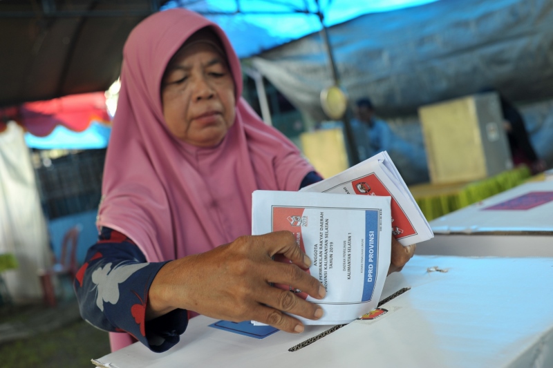 KOTAK SUARA: Pemilih memasukkan surat suara yang sudah dicoblosnya.