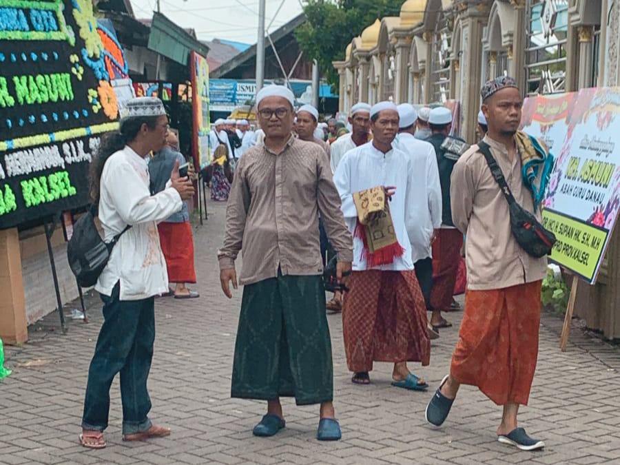TOTALITAS: Ketua Predam HSU, Hanif Tanjung (tengah) dan relawan saat ikut memandu jemaah Guru Danau di sekitar rumah duka, Sabtu (3/2/2024).(Foto: M Akbar/Radar Banjarmasin)
